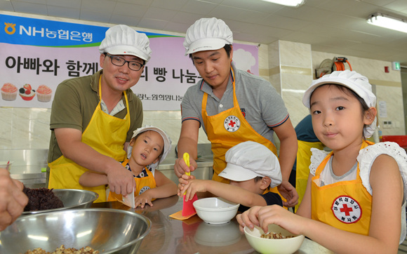 농협은행 나눔 봉사활동에 참여한 아이들이 아빠와 함께 사랑의 빵을 만들고 있다.ⓒ농협은행