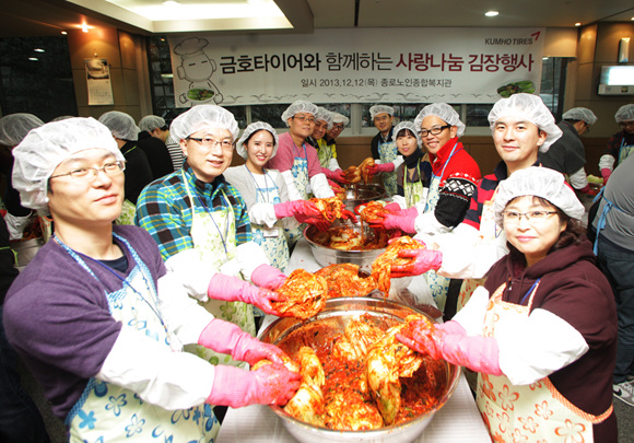 박세창 금호타이어 부사장(앞에서 세번째 줄의 빨간색 옷)과 임직원들이 김장김치를 담그고 있다.ⓒ금호타이어