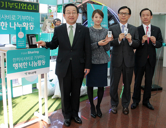 김종준 하나은행장(좌측 첫번째)과 한성수 부행장(좌측 세번째), 정수진 부행장(좌측 네번째) 등 임직원들이 신분증을 터치해 기부금을 내고 신분증을 들어 보이고 있다.ⓒ하나은행 