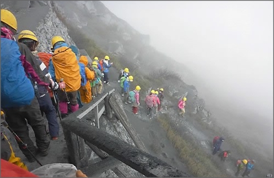 지난 27일(현지시간) 일본 나가노현과 기후현에 걸친 온타케산이 분화활동을 보인 가운데 등산객들이 화산재 등으로 자욱한 산을 내려오고 있다.ⓒ연합뉴스