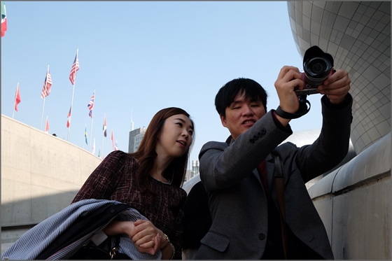 후지필름 한국법인 직원이 지난 18일 서울 중구 동대문디자인플라자(DDP)에서 시각장애인들을 도와 함께 사진을 찍고 있다.ⓒ후지필름일렉트로닉이미징코리아