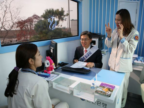 김영표 신한은행 부행장(가운데)이 이동점포 안에서 수화통역을 통해 금융상담을 진행하고 있는 모습.ⓒ신한은행 