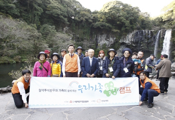 한화생명 홍보팀 서지훈 상무(앞줄 왼쪽에서 세번째)와 사랑의 장기기증 운동본부 박진탁 이사장(앞줄 왼쪽에서 네번째)이 ‘우리가족 힐링캠프’에 참여한 만성신부전 환우 가족들과 제주도 천지연 폭포에서 기념촬영을 하고 있다.ⓒ한화생명