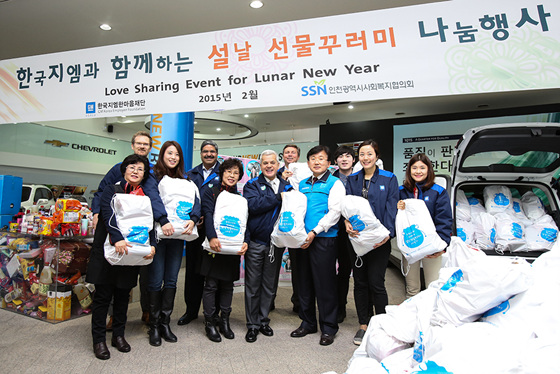 한국지엠 세르지오 호샤 사장(앞줄 왼쪽에서 네번째)과 인천사회복지협의회 한창원 회장(앞줄 왼쪽에서 다섯번째)을 비롯해 행사에 참석한 한국지엠 임직원 및 수혜기관 대표자들이 선물 꾸러미를 들고 웃고 있는 모습.ⓒ한국지엠