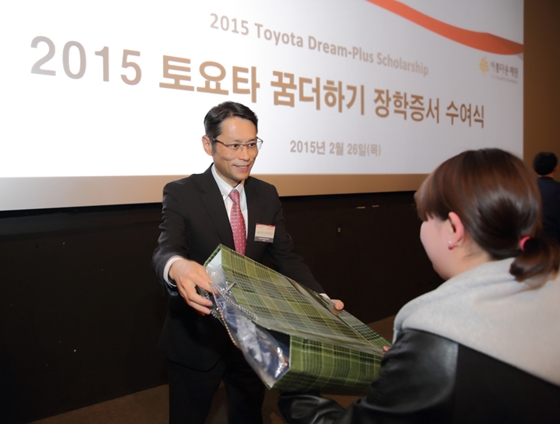 요시다 아키히사 한국토요타 사장이 지난 26일 열린 '2015 토요타 꿈 더하기 장학금' 수여식에서 선물을 전달하고 있다.ⓒ한국토요타