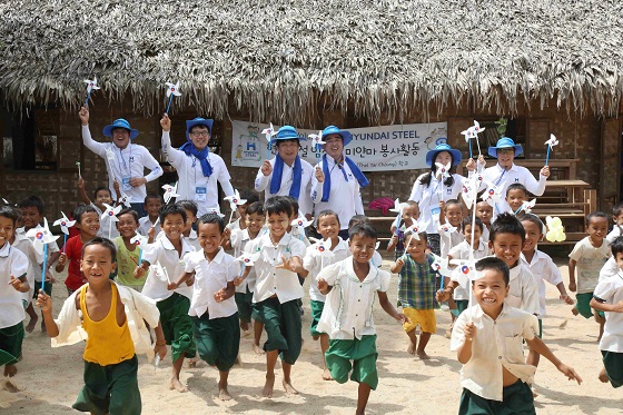 현대제철 직원들과 미얀마 현지 어린이들이 함께 만든 바람개비를 돌리며 즐거워하고 있다.ⓒ현대제철