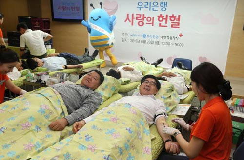 28일 서울 소공로 우리은행 본점에서 열린 '사랑의 헌혈 캠페인'에 이광구 은행장(오른쪽)과 박원춘 노조위원장이 참여해 헌혈을 하고 있다.ⓒ우리은행 