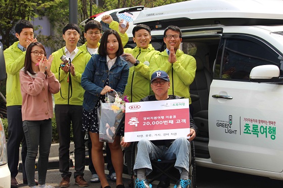 초록여행 2만번째 고객인 강용남씨에게 서프라이즈 고객 감동이벤트를 열고 기념품을 전달하고 있다. ⓒ기아차