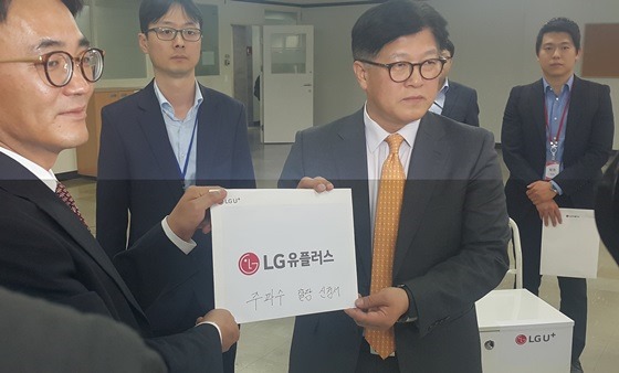 박형일 LG유플러스 상무(왼쪽에서 세 번째)가 지난달 18일 경기도 과천시 정부과천청사 미래부 이동통신용 주파수할당신청 접수처를 방문해 주파수할당신청서를 제출하고 있다.ⓒEBN