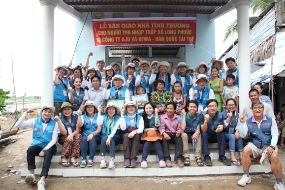 7월26일 베트남 해외자원봉사에 참가한 아주봉사단원들이 메콩강 인근 빈민촌 '사랑의 집짓기' 현장에서 현지 주민들과 기념촬영을 하는 모습 [제공=아주그룹]