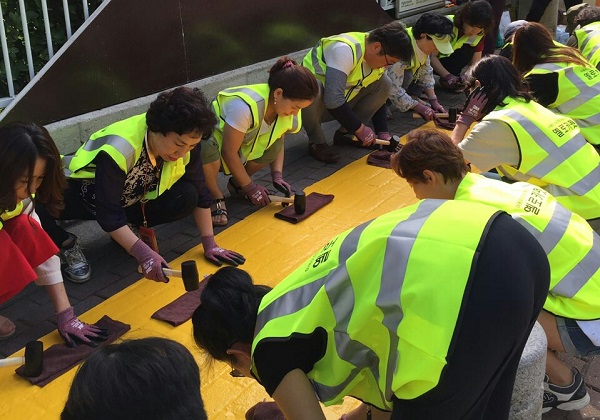 지난 5일 동부화재 강남사업단 소속 설계사들이 서울 서초초등학교 앞에서 '옐로카펫'을 설치하고 있다. ⓒ동부화재