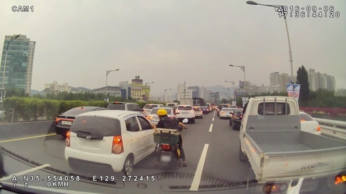 지난 6일 오후 울산 신삼호교에서 오토바이를 탄 시민이 구급차에 진로를 양보해 달라며 주변 차량 운전자에게 부탁하고 있다.ⓒ연합뉴스