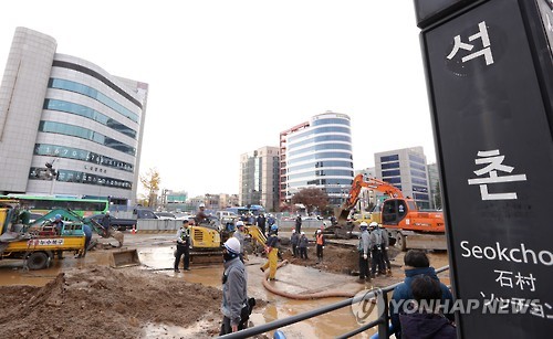 22일 서울 송파구 석촌역 사거리에서 소방 및 공사 관계자들이 상수도관 파열로 물바다가 된 도로를 복구 작업하고 있다. 