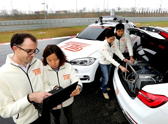 연구원들이 BMW 드라이빙센터 트랙에서 5G 시험망과 커넥티드카 성능을 최종 점검하고 있다. ⓒSKT