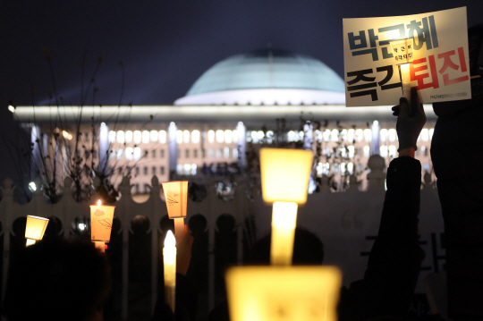 박근혜 대통령의 탄핵소추안 표결을 이틀 앞둔 7일 국회 앞에서 열린 '국민과 함께하는 촛불 문화제'에서 참가자들이 박근혜 대통령의 탄핵을 촉구하는 촛불을 들고 있다.ⓒ연합뉴스