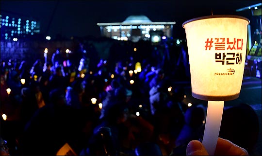 박근혜 대통령 탄핵소추안 국회 본회의 표결을 하루 앞둔 8일 저녁 국회 앞에서 열린 박근혜 대통령 탄핵 촉구 촛불집회에서 참가자들이 탄핵을 촉구하는 촛불을 들고 있다. ⓒEBN