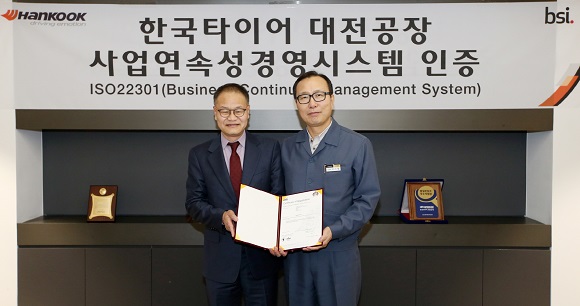 이기영 한국타이어 대전공장 공장장(오른쪽)과 이종호 BSI코리아(영국표준협회) 대표가 20일 대전공장에서 국제표준인증 ‘ISO22301’ 인증서를 들고 기념촬영을 하고 있다.ⓒ한국타이어