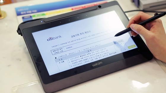 한국씨티은행 전국 지점에 구축된 와콤의 전자서명용 태블릿 'DTU-1141'을 이용하는 모습.ⓒ한국와콤