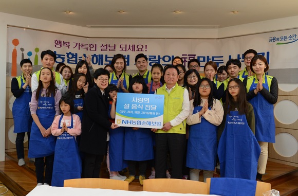 오성근 NH농협손해보험 부사장(앞줄 오른쪽 세번째)과 헤아림봉사단 20여명이 25일 서울 서대문구 소재 아동 보육시설 '송죽원'을 방문해 설맞이 만두를 빚고 기념촬영을 하고 있다. ⓒNH농협손해보험