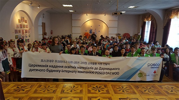포스코대우 키예프지사장과 현지 직원들이 다르니츠끼 고아원 교육물품 지원 전달식에서 고아원 아이들과 기념사진을 찍고 있다.