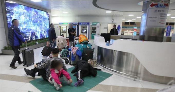 19일 강풍과 난기류로 제주공항의 항공기 운항이 차질을 빚은 가운데 공항에서 쪽잠을 청한 체류객들이 20일 오전 매트에 앉아 있다.ⓒ연합뉴스