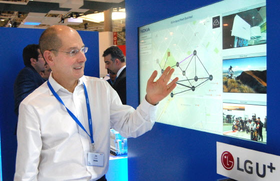 노키아 직원이 스페인MWC 노키아 부스에서 LG유플러스와 노키아가 공동 개발한 무선 백홀 기지국 성능을 나타내는 시뮬레이션 화면을 보여주고 있다. ⓒLG유플러스