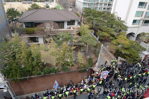 12일 오후 서울 강남구 삼성동 박근혜 전 대통령 사저 앞에 지지자들이 태극기와 성조기를 들고 탄핵 항의시위를 하고 있다.ⓒ연합뉴스
