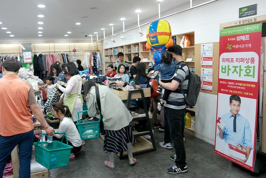 지난 22일 서울랜드 내 아름다운가게에서 진행된 ‘위메프 리퍼상품 바자회’를 방문한 고객들이 상품을 둘러보고 있다.ⓒ위메프