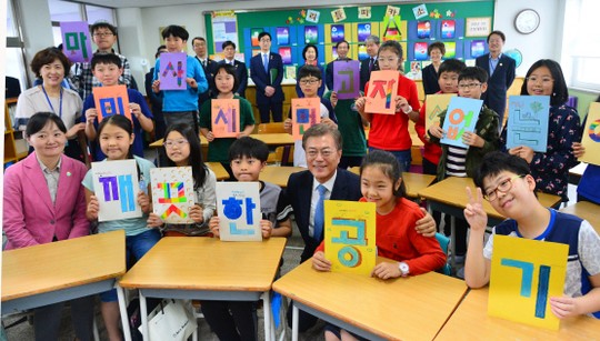 문재인 대통령이 15일 서울 양천구 은정초등학교에서 열린 ‘미세먼지 바로 알기 방문교실’에 참석해 학생들과 ‘깨끗한 공기’ 가 적힌 손 피켓을 들고 있다. ⓒ연합뉴스