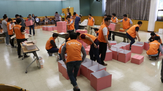 한화시스템 직원들이 31일 구미사업장에서 초록우산 어린이재단과 함께 지역 여성청소년에게 제공할 '사랑의 핑크박스'를 만들고 있다. [사진=한화시스템]