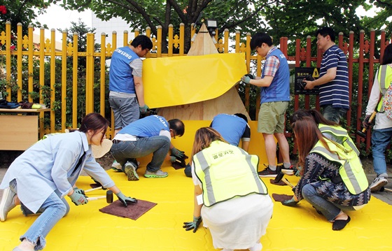 삼성전자 임직원 봉사자와 용인초등학교 학부모들이 아이들의 안전한 통학을 위해 학교 인근 횡단보도 앞에 '옐로카펫'을 설치하고 있다. ⓒ삼성전자