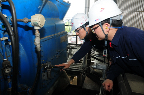 SK이노베이션 직원들이 압축기 감지센서 작동을 살펴보고 있다. 