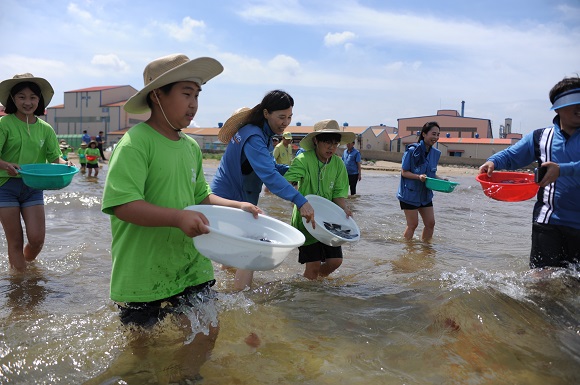 포스코켐텍이 2일 오후, 지역 어린이를 대상으로 푸른꿈 환경학교를 개최했다. 참가 어린이들과 임직원 봉사자들이 포항 청림동 해변에서 치어를 방류하는 모습.