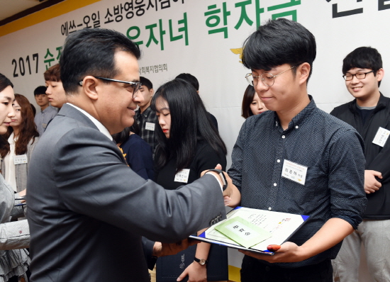 오스만 알 감디 에쓰오일 CEO(왼쪽)가 서울 영등포소방서에서 열린 2017 S-OIL 순직소방관 유자녀 장학금 전달식에서 수혜 학생에게 장학금을 전달하고 있다. [사진=에쓰오일]