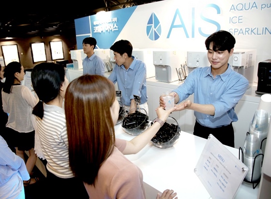 메가박스 코엑스점에 마련된 아이스 바에서 코웨이 AIS(아이스)로 만든 스파클링 워터를 고객이 건네 받고 있다.ⓒ코웨이