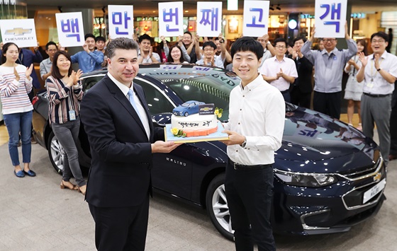 사진은 한국지엠 카허 카젬 사장(왼편)이 1백만 번째 고객으로 선정된 이상범씨(오른편)에게 축하 케익을 전달하고 있는 모습.ⓒ한국지엠