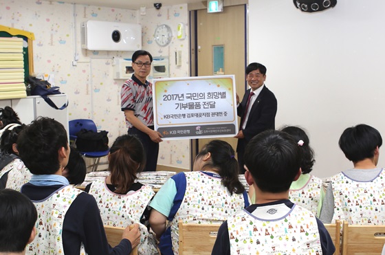 권대헌 KB국민은행 김포대곶지점 부지점장(오른쪽)이 '김포시 장애인주간보호센터’를 방문해 앞치마를 기부하고 있는 모습.ⓒKB국민은행
