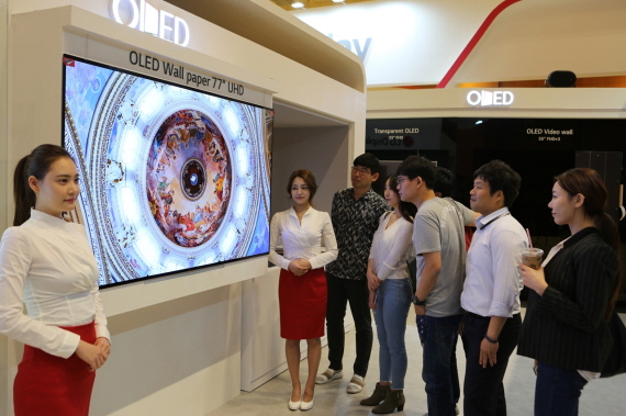 IMID 2017에 참가한 관람객들이 LG디스플레이 부스에서 77인치 UHD 월페이퍼 OLED를 감상하는 모습 