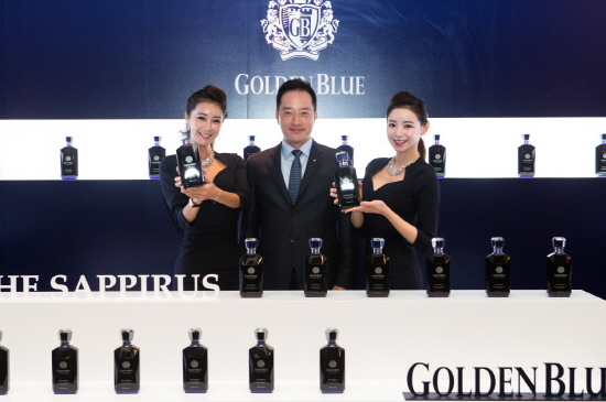 골든블루 김동욱 대표와 모델이 리뉴얼 골든블루 사피루스 제품을 들어보이고 있다.