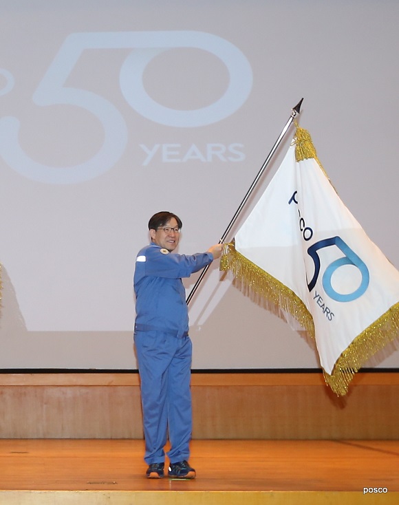 포스코 창립 50주년 맞아 포스코 권오준 회장이 1월 2일 시무식에서 창립 50주년 공식 엠블럼을 선포하고 엠블럼 깃발을 흔들고 있다