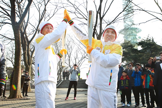 함영주 KEB하나은행장(사진 오른쪽)과 서홍석 (주)삼천리기계 대표(사진 왼쪽)가 ​2018 평창동계올림픽 성화봉송 행사에 참여해 평창동계올림픽 성공을 기원하는 하이파이브를 하고 있다.ⓒKEB하나은행