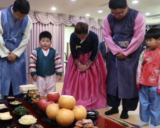 한국전통음식연구소에서 열린 '한국농수산식품유통공사(aT)와 함께하는 설 차례상 차리기'에서 한복을 입은 가족이 차례 시연하고 있다ⓒ연합뉴스