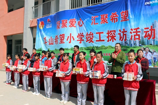 두산인프라코어가 최근 중국 산둥성 허쩌시에서 두산희망소학교 준공식을 열고 학생들에게 도서와 체육용품을 전달했다.ⓒ두산인프라코어