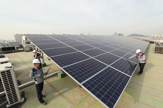서울 관악구의 KT 구로타워 옥상에 구축된 태양광 발전소에서 KT의 에너지 전문인력들이 태양광 발전시설을 점검하고 있다. ⓒKT