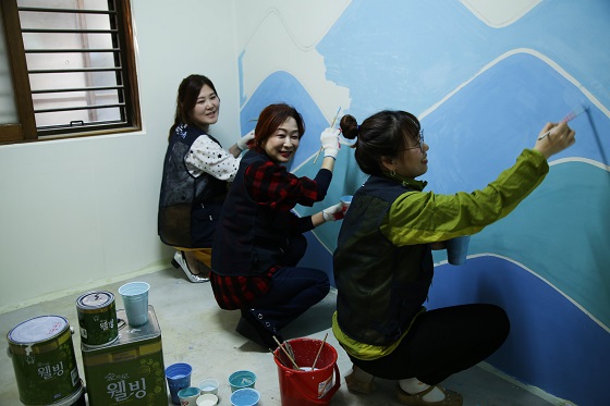 봉사자들이 KCC의 친환경 페인트로 벽면을 칠하며 주거환경개선 봉사활동을 진행하고 있다.[사진=KCC]
