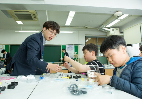 서울 개원초등학교 학생들이 주니어 공학교실에서 현대모비스 직원 강사들의 도움을 받아 태양광 자동차를 만들고 작동해보고 있다.ⓒ현대모비스