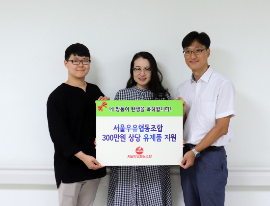 서울우유협동조합이 네 쌍둥이를 출산한 김정화씨 부부에게 지원 기증서를 전달하고 기념촬영을 하고 있다.
