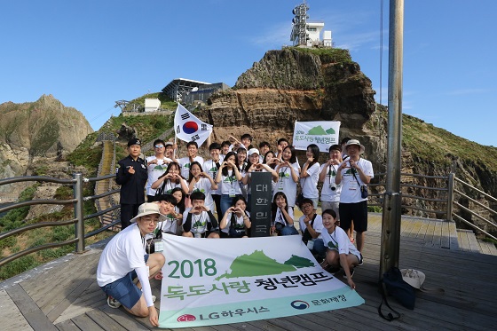 독도사랑 청년캠프에 참가한 대학생 및 관계자들이 22일 독도 입도에 성공해 '대한민국'이 세겨진 독도 표지석에서 기념 촬영을 하고 있는 모습[사진=LG하우시스]