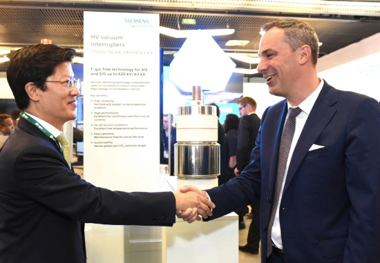 허정석 일진전기 부회장(왼쪽)과 세드릭 나이케(Cedrik Neike) 독일 지멘스 부회장이 프랑스 파리에서 열린 '2018 국제 대전력망 기술협의회'에서 친환경 가스절연개폐장치의 핵심부품을 선보이고 있다.
