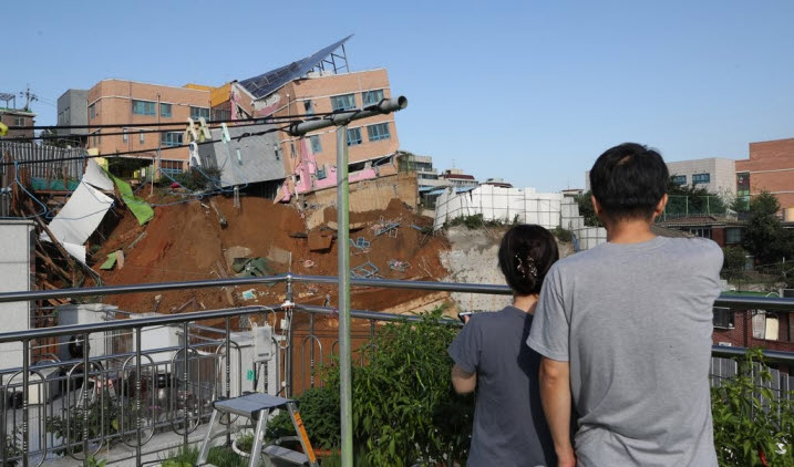 일 오전 서울 동작구 상도동 다세대주택 공사장의 흙막이가 무너져 근처에 있는 상도유치원 건물이 기울어져 위태롭게 서 있는 가운데 주민들이 현장을 바라보고 있다ⓒ연합뉴스